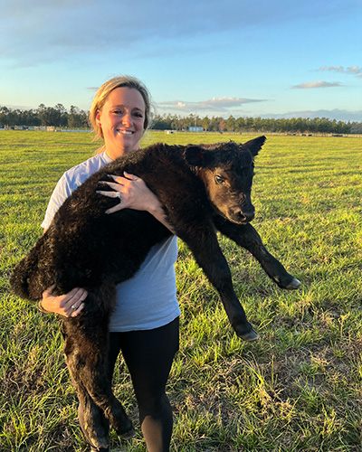 Woman holding a calf.